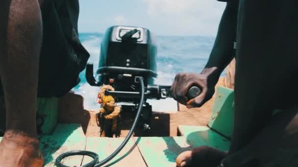 Africano controla el motor fueraborda en un viejo barco de pesca, Zanzíbar, Tanzania — Vídeo de stock