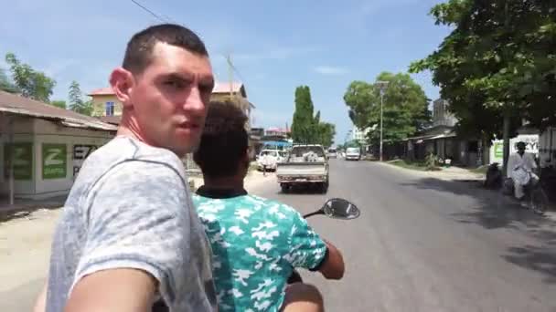 Paardrijden scooter door drukke Afrikaanse weg met links verkeer, Stone Town, Zanzibar — Stockvideo