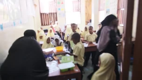 アフリカの小学校の子供たちザンジバルの教室の机に座る — ストック動画