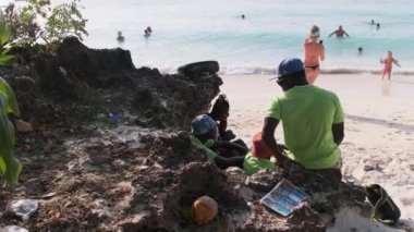 Yerel sahil gezginleri ya da sahil çocukları plajda dinleniyor.