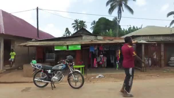 Rijden langs slurven en vlooienmarkten met verdunde huizen onder in het dorp — Stockvideo