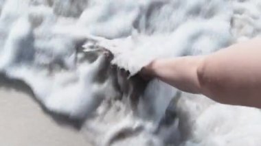 Ocean Shore 'un Beyaz Kum ve Sörf Dalgaları' ndan Yürüyen Genç Bir Kadının Bacakları POV 'u