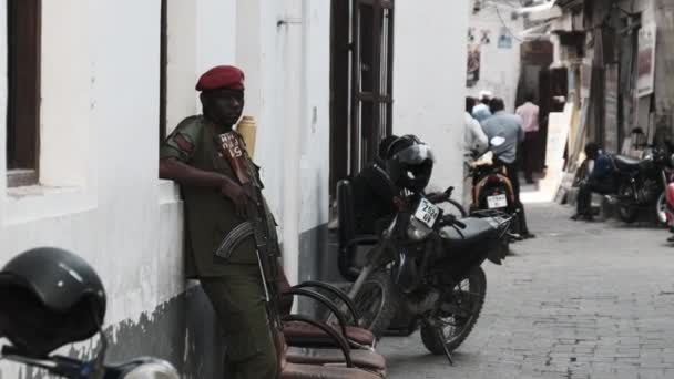アフリカの貧しい地域の路上で機関銃を持つ武装アフリカの兵士 — ストック動画