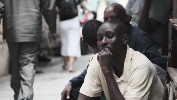 Smutný Afričan sedí na chudé ulici, místní černoch, smutný pohled, kamenné město, Zanzibar — Stock video