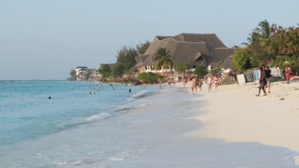 Πανόραμα εξωτικής αμμώδους παραλίας με γαλαζοπράσινο ωκεανό, τουρίστες που ξεκουράζονται, Ζανζιβάρη — Αρχείο Βίντεο