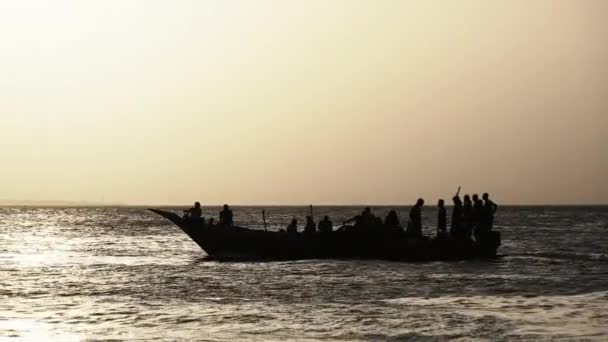 日没時に海洋を航海する漁師とアフリカ漁船のシルエット — ストック動画