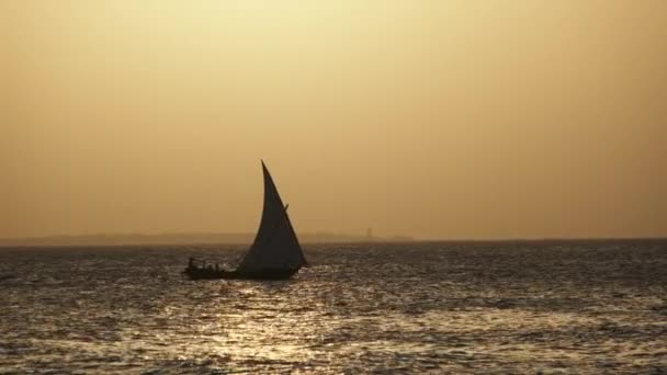 Silueta African Wooden Dhow Boat Plachtění u oceánu při západu slunce, Zanzibar, Afrika — Stock video