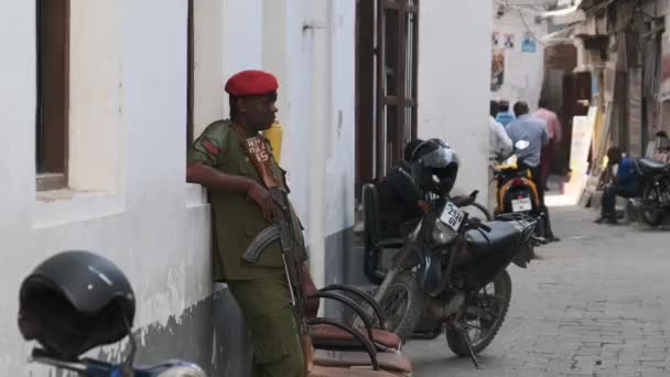 En beväpnad afrikansk soldat med maskingevär på gatan i fattiga regionen i Afrika — Stockvideo