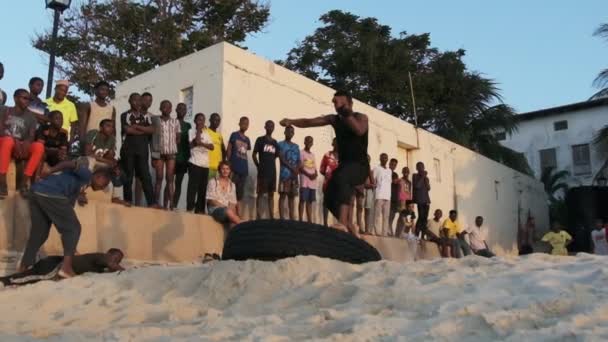 Afrikanische Jugendliche organisieren Akrobatik-Show am Strand bei Sonnenuntergang, Sansibar — Stockvideo