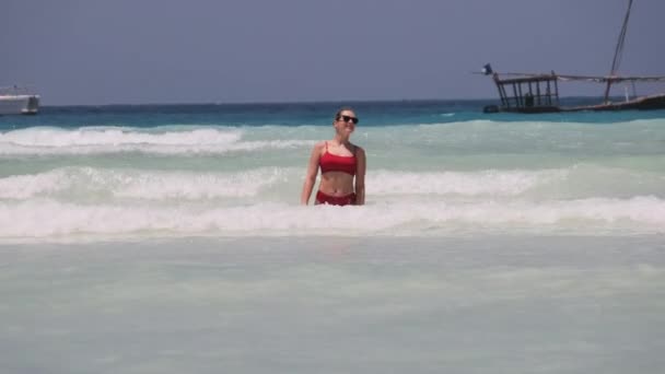 Młoda kobieta w czerwonym stroju kąpielowym odpoczywa i kąpie się w oceanie na Paradise Beach — Wideo stockowe