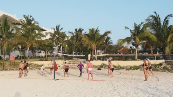 Turistas jogam vôlei de praia em um hotel tropical em uma praia de areia, Zanzibar — Vídeo de Stock