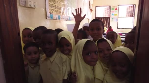 भीड़ अफ्रीकी बच्चे एक प्राथमिक स्कूल, ज़ंज़ीबार के अंदर एक कैमरा में देखो — स्टॉक वीडियो