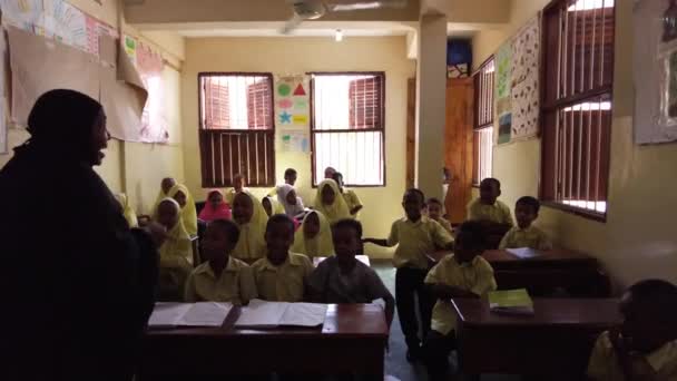 Kinder in einer afrikanischen Grundschule sitzen an Schreibtischen in einem Klassenzimmer, Sansibar — Stockvideo