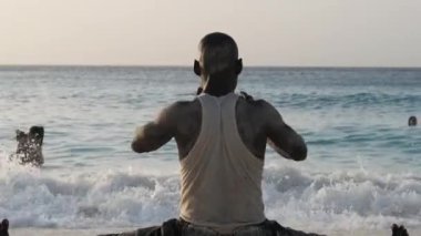 Atletik Afrikalı Adam Twine 'ın üzerine oturdu ve Okyanus kıyısındaki spor için sahile gitti.