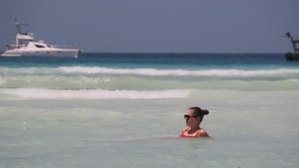 Schöne schlanke Frau in rotem Badeanzug badet und ruht im Ozean am Paradise Beach