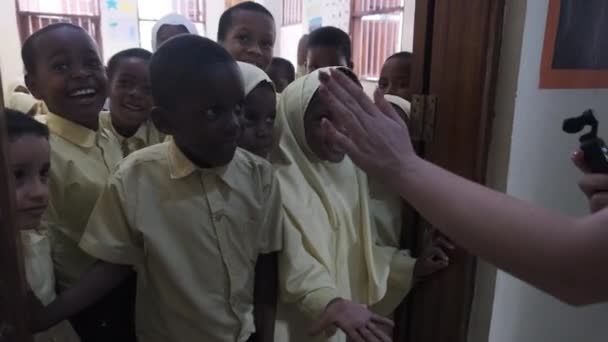 Menigte Afrikaanse kinderen kijken in een camera in een basisschool, Zanzibar — Stockvideo