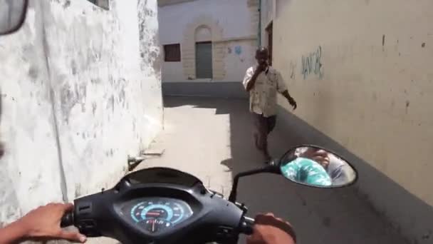 Jízda na skútru v úzkých špinavých ulicích kamenného města s chudými Afričany — Stock video