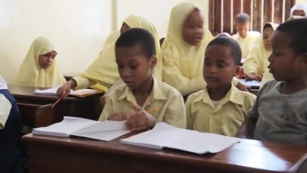Παιδιά σε ένα Αφρικανικό Δημοτικό Σχολείο κάθονται σε γραφεία σε μια τάξη, Ζανζιβάρη — Αρχείο Βίντεο