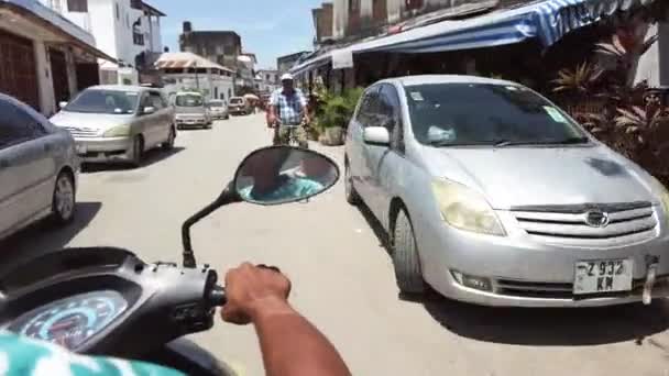 Cavalcare uno scooter di Narrow Dirty Streets of Stone Town con i poveri africani — Video Stock