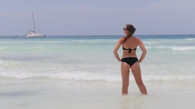Bikini 'deki Genç Kadın Sahilde Duruyor ve Turkuaz Okyanusu' na Bakıyor. Zanzibar