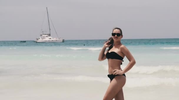 Młoda kobieta w bikini pozująca na egzotycznej plaży na turkusowym oceanie, Zanzibar — Wideo stockowe