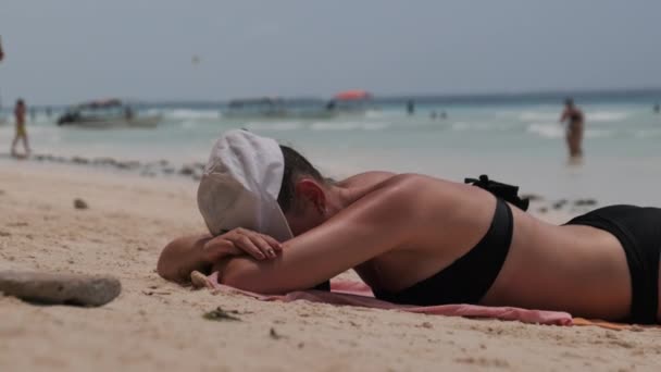 Young Woman Sunbathes on a Paradise Sandy Beach Lying in Black Bikini near Ocean — Stock Video