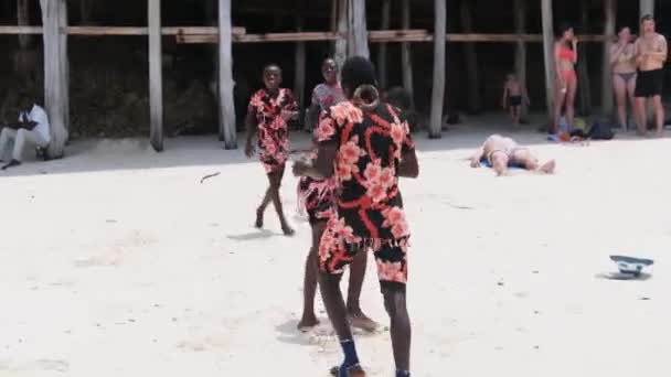 地元のアフリカ人がビーチ、ザンジバルの観光客のためのアクロバティックなスタントを行う — ストック動画