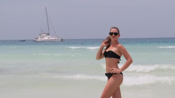 ターコイズブルーの海でエキゾチックなビーチにポーズをとるビキニの若い女性、ザンジバル — ストック動画