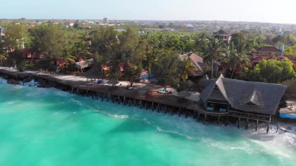 Tropische Luftlandschaft von Sansibar, Wellen treffen Riff an Hotelküste, Palmen — Stockvideo