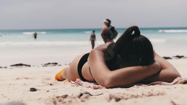 Jonge vrouw zonnebaden op een paradijs zandstrand liggend in zwarte Bikini in de buurt van Ocean — Stockvideo