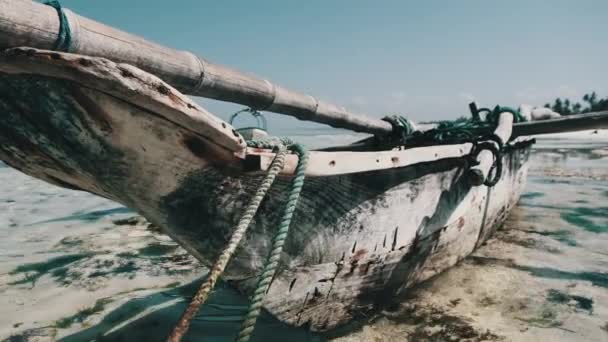 アフリカの伝統的な木製ボートは、ザンジバルのロータイドにあるビーチで砂に囲まれています — ストック動画