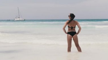 Bikini 'deki Genç Kadın Sahilde Duruyor ve Turkuaz Okyanusu' na Bakıyor. Zanzibar