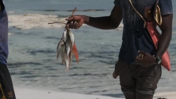 ザンジバルの地元の男に魚の販売の束を持つアフリカの漁師 — ストック動画