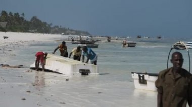 Bir Afrikalı Balıkçı Zanzibar, Low Tide 'da Algae' den bir tekne temizliyor.