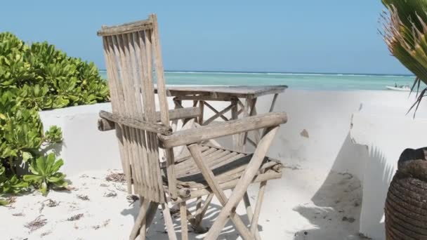 Стол и стул с видом на лазурный пляж и Индийский океан, Занзибар — стоковое видео