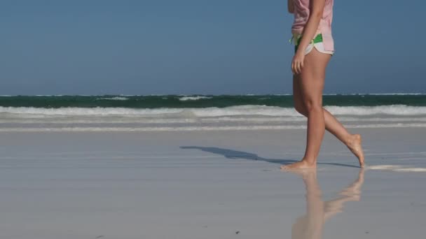 Beine einer jungen Frau am White Sand Paradise Beach mit Wellen des Gezeitenmeeres — Stockvideo