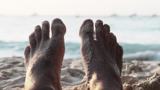 海によってサンディビーチに横たわっている若い男のPOV足日没の間に,ザンジバル — ストック動画