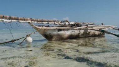 Yaşlı, Afrika Balıkçı Kayığı Low Tide, Zanzibar 'daki kumsalda mahsur kaldı.