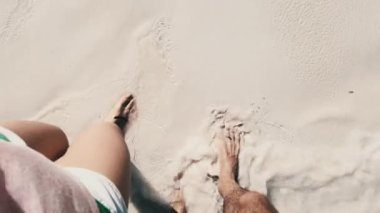 Ocean Shore 'un Beyaz Kum ve Sörf Dalgaları' ndan Yürüyen Genç Bir Çiftin POV Bacakları