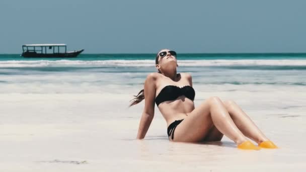 Young Woman in Black Bikini Tans on a Paradise White Sandy Beach ligt bij Ocean — Stockvideo