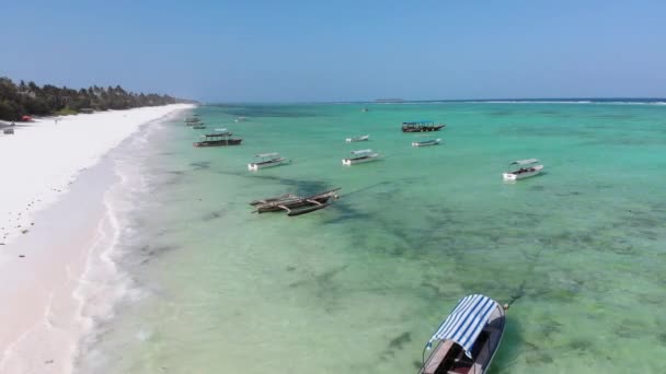 Los barcos están anclados frente a la costa en aguas poco profundas, el océano en marea baja, aéreo, Zanzíbar — Vídeo de stock