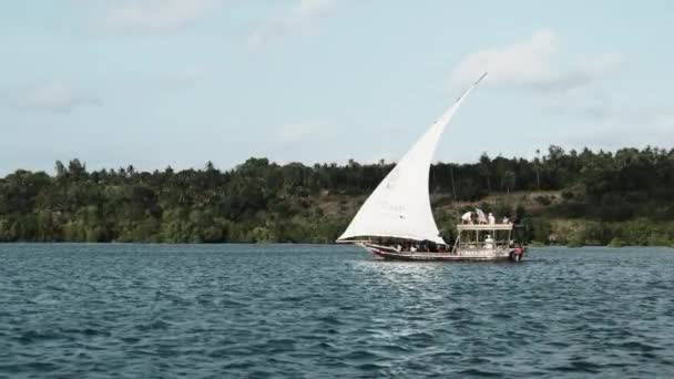 Bateau traditionnel africain avec des touristes flotte sous la voile ouverte par l'océan — Video