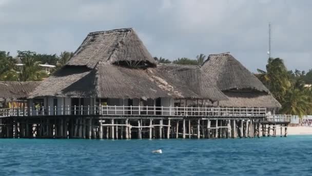 Afrikanisches Restaurant mit Strohdach auf Holzpfählen über dem Ozean. Sansibar — Stockvideo