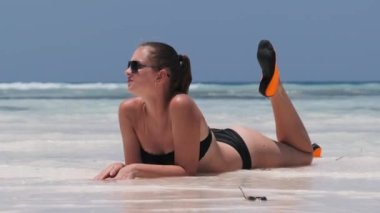 Siyah Bikinili Genç Kadın Cennetteki Beyaz Kumlu Kumsalda Ocean 'da yatıyor