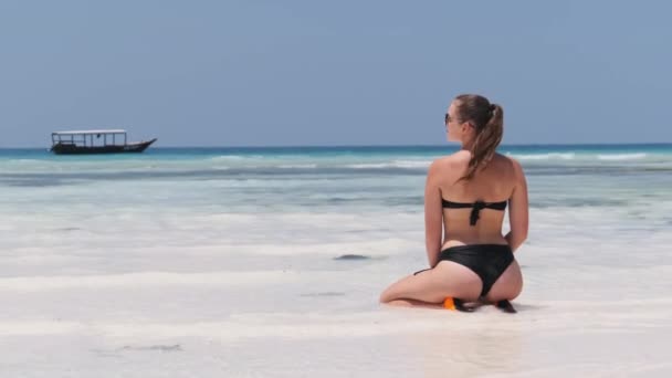 Mulher jovem de biquíni preto Tans in Lotus Pose on Paradise Sandy Beach by Ocean — Vídeo de Stock