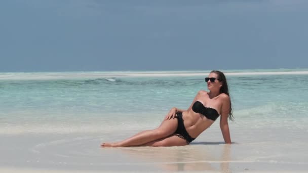 Giovane donna in bikini abbronzata su una spiaggia paradisiaca vuota sull'isola nell'oceano, Mnemba — Video Stock