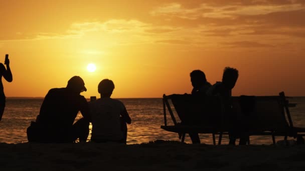 Silhuett par medelålders man och kvinna vid solnedgången på stranden vid havet — Stockvideo