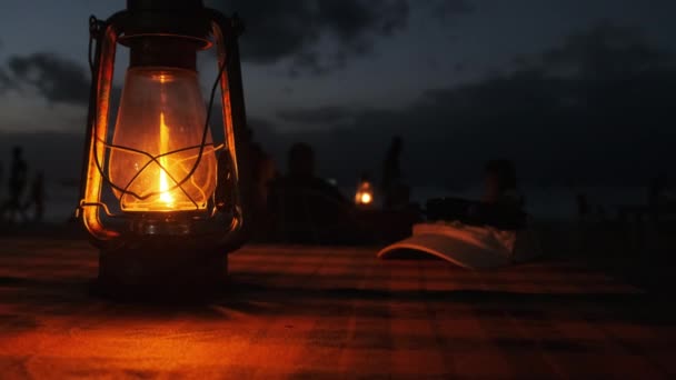 Ρομαντικό δείπνο Candlelit από Ocean Beach τη νύχτα, λάμπα κηροζίνης αναμμένο στο τραπέζι — Αρχείο Βίντεο