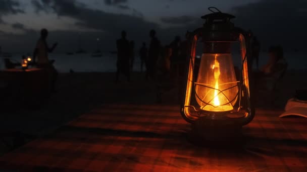 浪漫的烛光晚餐在海滩边，煤油灯在桌上点着 — 图库视频影像