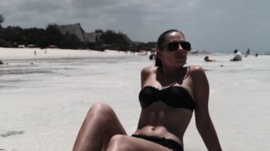 Siyah Bikinili Genç Kadın Cennetteki Beyaz Kumlu Kumsalda Ocean 'da yatıyor